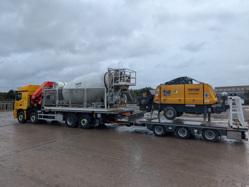 HIAB and drag vehicle transports agitator and concrete pump